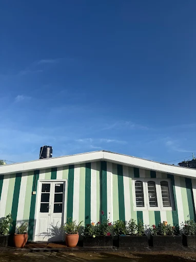 The green and white farm house under a clear blue sky