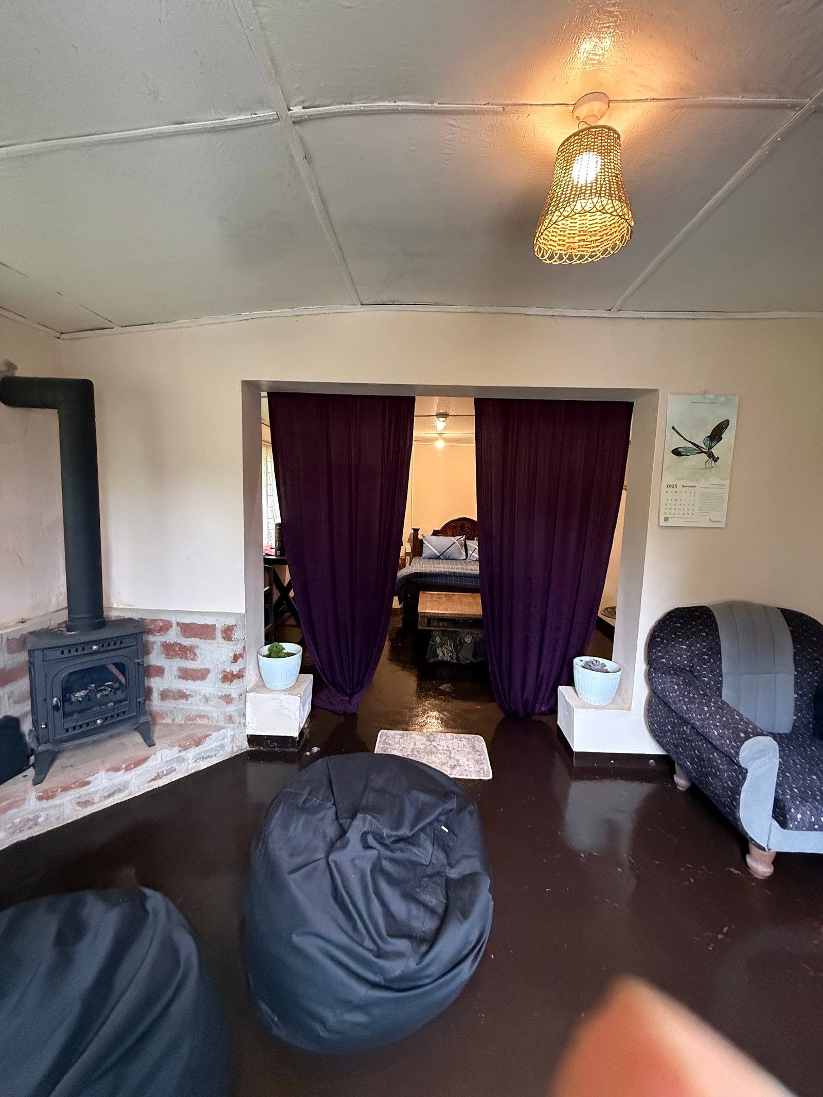 The living room with a wood stove and armchairs