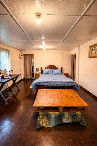 A guest room with a double bed and a wooden table